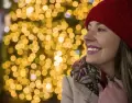 Una mujer sonr�e con luces vibrantes de fondo: una t�pica postal de la Navidad en Madrid.
