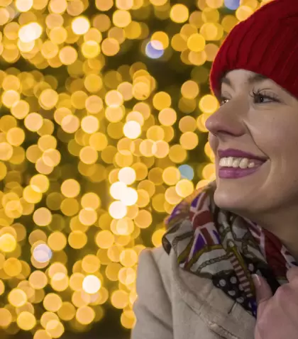 Una mujer sonr�e con luces vibrantes de fondo: una t�pica postal de la Navidad en Madrid.