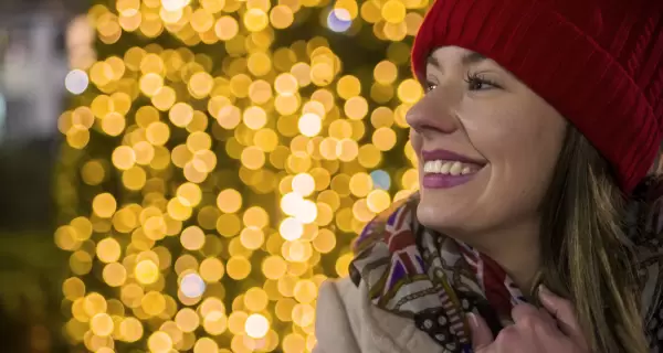 Una mujer sonr�e con luces vibrantes de fondo: una t�pica postal de la Navidad en Madrid.