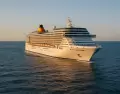 Un moderno crucero surcando el mar durante el atardecer, ideal para quienes viajan por primera vez.