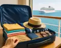 Valija lista con ropa, sombrero y pasaporte, con vista al mar y un crucero en el horizonte.