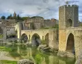 Pueblo de Besal� en abril con puente medieval y paisaje verde.