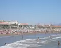 Playa urbana de Valencia en julio, con gente ba��ndose en el Mediterr�neo, agua tranquila, arena clara, sombrillas y ambiente c�lido.