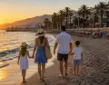 Familia paseando por una playa andaluza al atardecer.